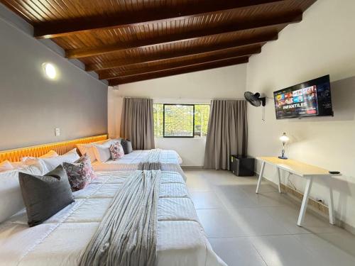 a large bedroom with two beds and a desk at Laureles Boutique Stay in Medellín