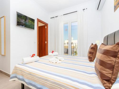 a white bedroom with a blue and white striped bed at Modern Villa with Pool in Cala d'Or in Cala D'or