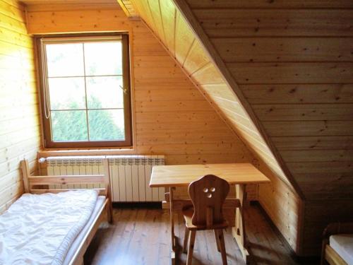 a room with a table and a bed in a cabin at Noclegi Pod Małym Królem in Ustrzyki Dolne