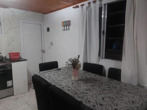 a dining room with a table with a potted plant on it at La casita in San Clemente del Tuyú