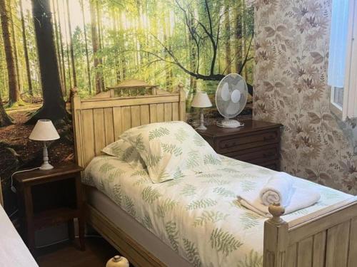 a bedroom with a bed with a forest mural on the wall at Maison spacieuse avec jardin, proche activités, climatisée, vélos, et lits faits à l'arrivée - FR-1-489-284 in Couleuvre