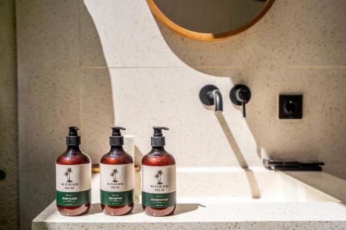 three bottles of wine sitting on a counter in a bathroom at Kuta Beach Villas by Great Bali Villas in Badung