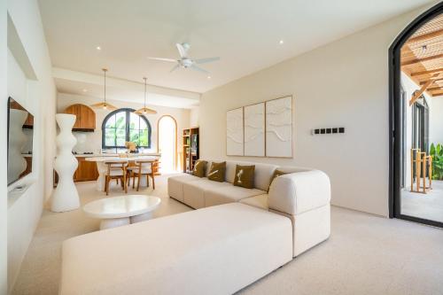 a living room with a white couch and a table at Kuta Beach Villas by Great Bali Villas in Badung