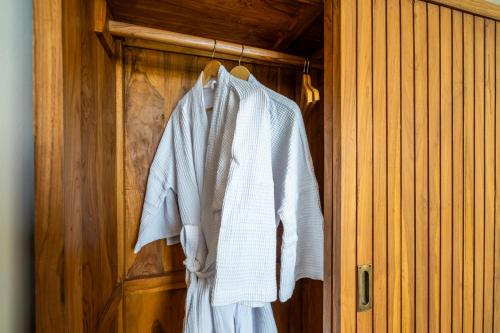 a white shirt and tie hanging on a wooden door at Kuta Beach Villas by Great Bali Villas in Badung