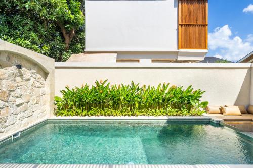 a swimming pool in front of a house at Kuta Beach Villas by Great Bali Villas in Badung