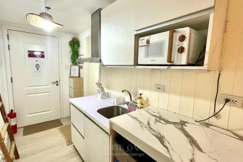a kitchen with a sink and a microwave at Minimalist Spot for Couples with PS4, Netlix and Instax in San Fernando