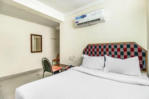 a hotel room with a bed and an air conditioner at SPOT ON Swarna Mayuri in Guntūr