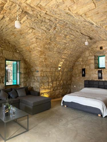 a bedroom with a bed and a stone wall at Yassmina Guest House in Maasser El Chouf