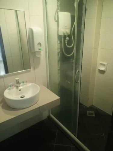 a bathroom with a sink and a shower with a mirror at Marina sunset view in Lumut