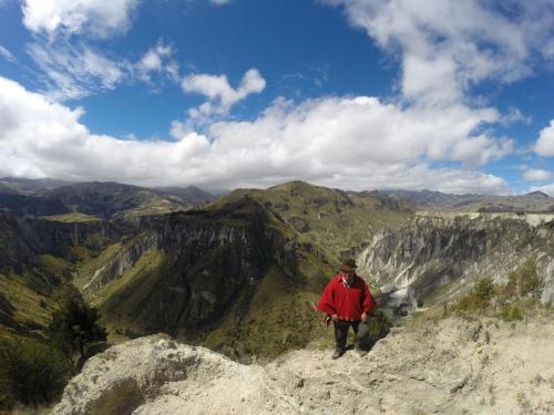 a man standing on top of a mountain at Hosteria Alpaka Quilotoa in Quilotoa