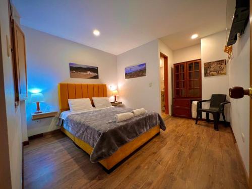a bedroom with a bed and a desk and a chair at Hotel Boutique Casa Lili in Tunja