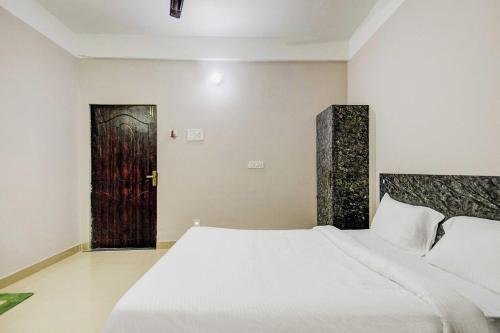 a bedroom with a large bed and a door at Hotel O Sai villa in Dispur