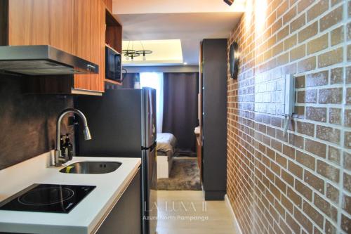 a kitchen with a sink and a brick wall at Unique Studio for Couples with Netflix & Mt Arayat View in San Fernando