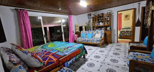 a bedroom with a bed and a couch in a room at Tiapaa Village in Maupiti