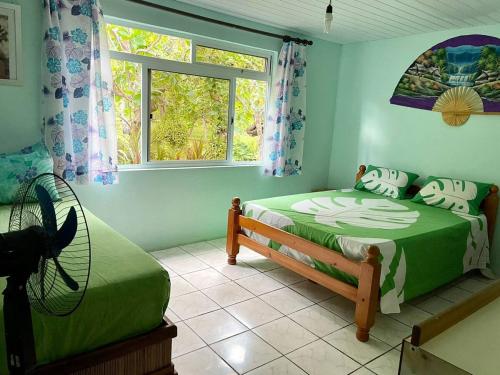 a bedroom with two beds and a window at Tiapaa Village in Maupiti