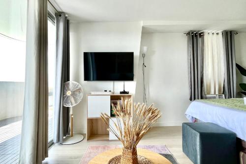 a living room with a bed and a flat screen tv at Entire 1BR Queen Bed with Spacious Beach View Balcony in San Fernando