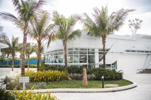 a building with palm trees in front of it at Entire 1BR Queen Bed with Spacious Beach View Balcony in San Fernando