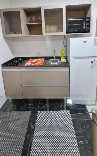 a small kitchen with a sink and a stove at Complejo Junin Temporarios in Formosa