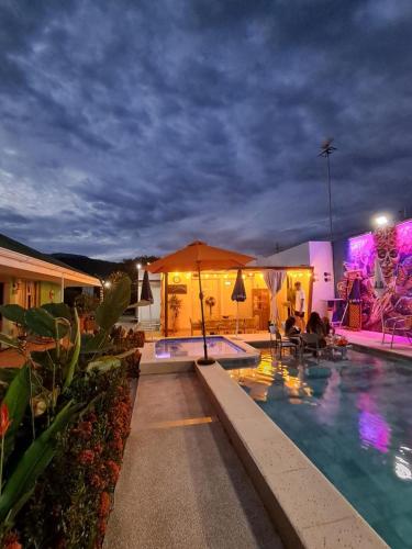 a hotel with a swimming pool at night at Casa Turística Don Juan in Ibagué