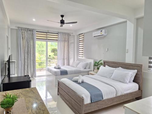 a bedroom with two beds and a television in it at INATO SUITES Rm 2 2 queen beds in Panglao Island