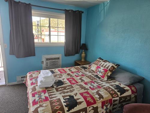 a bedroom with a bed with a quilt on it at Two Rivers Inn in Thermopolis