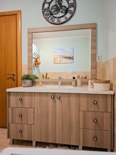 a bathroom with a sink and a large mirror at Apartman ELLA in Peračko Blato