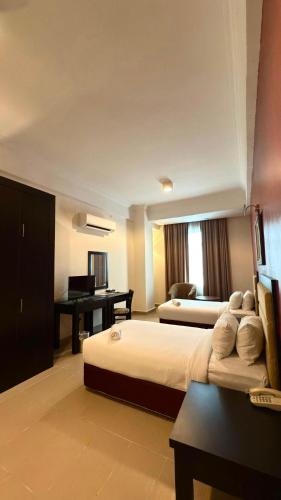 a bedroom with a bed and a desk with a piano at Puteri Bay Hotel in Melaka