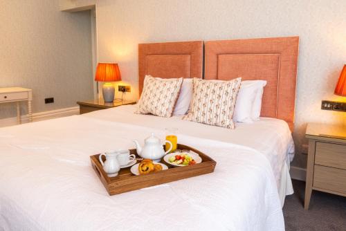 a tray with a tea set on a bed at Best Western Plus The Connaught Hotel and Spa in Bournemouth