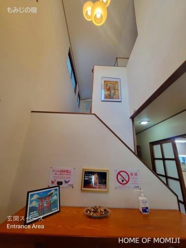 a staircase with a wooden table in a house at もみじの宿別府 in Beppu
