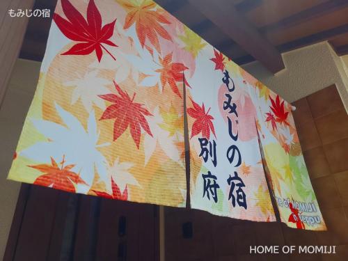 a stage with a banner with autumn leaves on it at もみじの宿別府 in Beppu