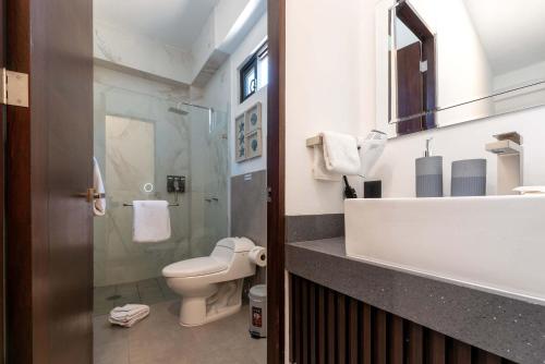 a bathroom with a toilet and a sink and a mirror at Vista Pedregal-Modern Vacation Apartment Walk to Marina & Beaches in Cabo San Lucas