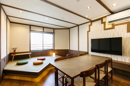 a living room with a table and a tv at Yaba Stay in Nagoya