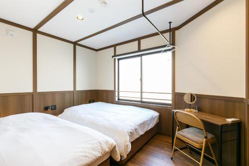une chambre avec un lit, un bureau et une chaise dans l'établissement Yaba Stay, à Nagoya