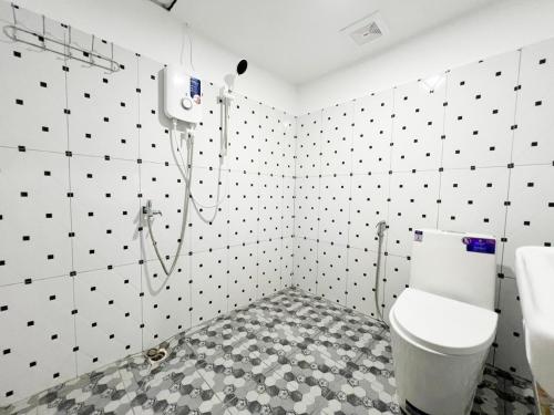 a bathroom with a white toilet and black and white tiles at SELA Bungalow and Italian Restaurant in Koh Rong