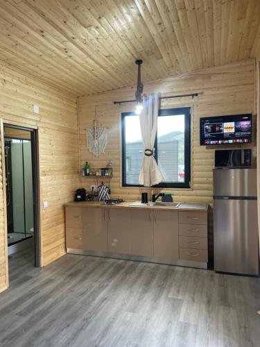 a kitchen in a wooden cabin with a window at Maya Lake House Ponton Bicaz 