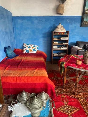 a bedroom with a bed with a red blanket at Halima Guesthouse in Larache