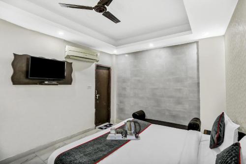 a room with a bed and a tv on the wall at Collection O AP Grand in Noida