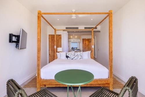 a bedroom with a bed and a green table at Hotel El Ganzo - Adults Only in San José del Cabo