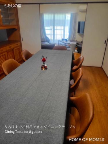 a table in a room with a dining table for guests at もみじの宿別府 in Beppu