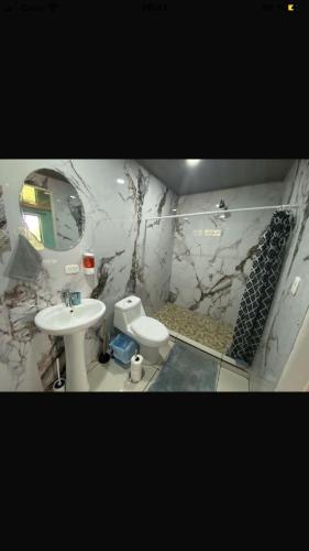 a bathroom with a sink and a toilet and a mirror at Casa de playa in Playa Avellana