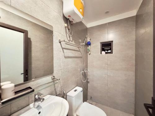 a bathroom with a toilet and a sink and a mirror at The Little Home - Hoàng Hoa Thám - Cosy apartment - Center Hanoi in Hanoi