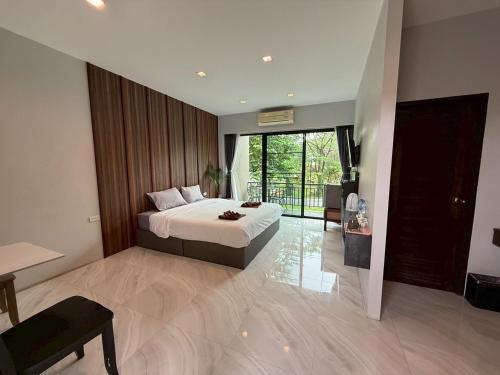 a bedroom with a bed and a large window at 549 Resort & Cafe Lamphun in Ban Mae Pok