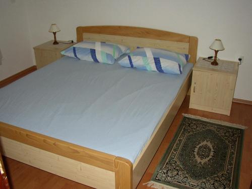 a bedroom with a wooden bed with two night stands at Apartments Jadranka in Pula