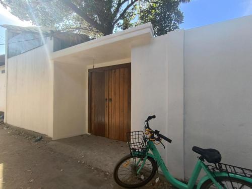 Una bicicleta verde estacionada al lado de un edificio con una puerta en Villa AnTeak, en Gili Air