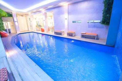 a large swimming pool with blue water in a building at Goldberry Lite Hotel in Iloilo City