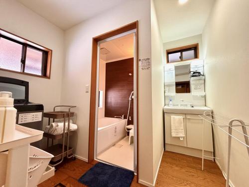 a bathroom with a tub and a sink and a toilet at 古民家ｓｔｙｌｅ富山駅北 in Toyama