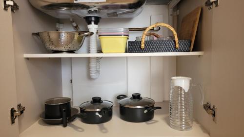 a kitchen counter with pots and pans and a sink at Apartamento 5 estrelas próximo ao Shopping e USP in Bauru