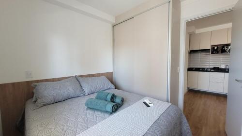 a bedroom with a bed with blue pillows on it at Apartamento 5 estrelas próximo ao Shopping e USP in Bauru