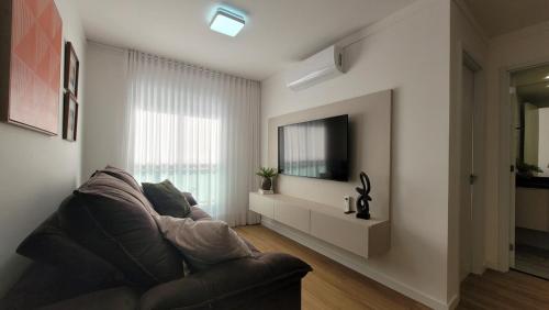 a living room with a couch and a television at Apartamento 5 estrelas próximo ao Shopping e USP in Bauru