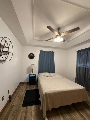 a bedroom with a bed and a ceiling fan at Cozy and close to everything in Alamo
